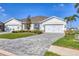Well-maintained exterior showcasing a three-car garage and landscaped front yard at 16273 Coconut Palm Dr, Port Charlotte, FL 33953
