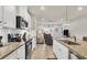 This gourmet kitchen has stainless appliances, granite counters, white cabinets, tile backsplash, and views to the living room at 16273 Coconut Palm Dr, Port Charlotte, FL 33953