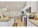 Bright kitchen features white cabinets, stainless appliances, tile backsplash, granite counters, and an open view to the dining area at 16273 Coconut Palm Dr, Port Charlotte, FL 33953