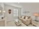 Cozy living room with neutral tones, comfortable seating, and bright natural light from the nearby window at 16273 Coconut Palm Dr, Port Charlotte, FL 33953