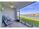 Relaxing screened patio offers serene water views with comfortable seating and a ceiling fan for comfort at 16273 Coconut Palm Dr, Port Charlotte, FL 33953