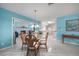 Bright dining room featuring stylish lighting, unique decor, and an open layout leading into the kitchen and living areas at 1690 Edith Ave, Englewood, FL 34223