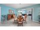 Cozy dining room featuring a glass table, elegant chairs, and a view into the living room with a fireplace at 1690 Edith Ave, Englewood, FL 34223