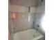 Updated shower featuring marble tiling, hexagon tile accents, and a built-in niche at 172 Coblentz St, Port Charlotte, FL 33954
