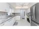 Well-lit kitchen with stainless appliances, white cabinets, and stone tile backsplash at 1720 Florence Ave, Englewood, FL 34223