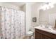 Cozy bathroom featuring a shower with a seashell-themed curtain, and a sink with a dark-wood vanity at 19241 Serafina St, Venice, FL 34293