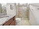 Bathroom with granite countertops, tiled shower with glass door, tile floors, and modern fixtures at 19241 Serafina St, Venice, FL 34293