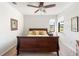 Bright bedroom with a large window overlooking the lake, featuring a wood bed and ceiling fan at 19241 Serafina St, Venice, FL 34293