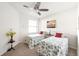 Bright bedroom featuring twin beds with matching seashell-themed bedding and a ceiling fan at 19241 Serafina St, Venice, FL 34293