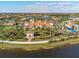 Beautiful aerial view of the clubhouse featuring a terracotta roof, palm trees, and manicured lawn at 19241 Serafina St, Venice, FL 34293
