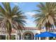 Beautiful clubhouse with a red tile roof framed by palm trees under a bright blue sky at 19241 Serafina St, Venice, FL 34293