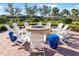 Inviting fire pit area with comfortable seating, surrounded by lush landscaping and mature trees at 19241 Serafina St, Venice, FL 34293