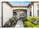 Cozy front porch featuring chairs, plants, and a brick walkway leading to the front door at 19241 Serafina St, Venice, FL 34293