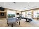 Well-lit game room featuring ping pong and pool tables, dartboard, and multiple windows for natural light at 19241 Serafina St, Venice, FL 34293
