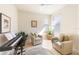 Inviting living room featuring a cozy chair, piano, and a bright window at 19241 Serafina St, Venice, FL 34293