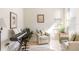 Inviting living room featuring a cozy chair, piano, and a bright window at 19241 Serafina St, Venice, FL 34293