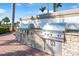 Outdoor kitchen area featuring stainless steel grills and stone accents, perfect for entertaining guests at 19241 Serafina St, Venice, FL 34293