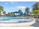 Inviting community pool featuring lounge chairs, umbrellas, and palm trees at 19241 Serafina St, Venice, FL 34293