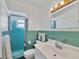 Clean bathroom featuring turquoise tile accents, a glass enclosed shower, and modern fixtures at 1960 Mississippi Ave, Englewood, FL 34224