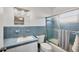Well-lit bathroom with blue tiling, a glass shower door, and updated vanity at 1960 Mississippi Ave, Englewood, FL 34224