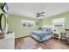 Cozy bedroom with two windows, hardwood floors, ceiling fan, and charming decor at 1960 Mississippi Ave, Englewood, FL 34224