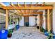 Charming brick patio with pergola and a variety of potted plants creating a peaceful outdoor space at 1960 Mississippi Ave, Englewood, FL 34224