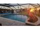Enjoy sunset views from this screened-in pool area with brick pavers and tropical landscaping at 1960 Mississippi Ave, Englewood, FL 34224