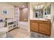 Bathroom featuring a tub with tiled walls, a vanity with cabinets, and tiled floors at 20110 Ragazza # 102, Venice, FL 34293