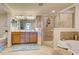 Bathroom featuring a double vanity, soaking tub, glass shower, and tiled flooring at 20110 Ragazza Cir # 102, Venice, FL 34293