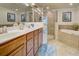 Bright bathroom showcasing double sinks, a walk-in shower with glass doors, and a soaking tub for relaxation at 20110 Ragazza Cir # 102, Venice, FL 34293