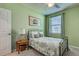 The vibrant green bedroom is brightened with a fan and a window at 20110 Ragazza Cir # 102, Venice, FL 34293