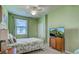 Bright bedroom featuring green walls, ceiling fan, natural light, and TV at 20110 Ragazza Cir # 102, Venice, FL 34293