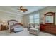 Well-lit bedroom with a ceiling fan, dresser, chair, and large window with bright natural light at 20110 Ragazza Cir # 102, Venice, FL 34293