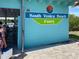 South Venice Beach Ferry turquoise building with palm trees at 20110 Ragazza Cir # 102, Venice, FL 34293