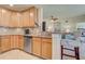 Well-lit kitchen featuring wood cabinets, granite countertops, stainless steel appliances, and an adjacent breakfast bar at 20110 Ragazza Cir # 102, Venice, FL 34293