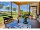 Outdoor dining on a screened lanai with furniture and serene views of the green landscape at 20110 Ragazza Cir # 102, Venice, FL 34293