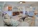 An open-concept living area with tile flooring, leather furniture, and a TV with a nature scene at 20110 Ragazza Cir # 102, Venice, FL 34293