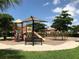 Community playground with a slide, swings, climbing structures, and a shaded bench at 20110 Ragazza Cir # 102, Venice, FL 34293