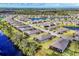 An aerial view showcases homes in a waterfront community with lush landscaping and lake views at 2088 Bonito Way, Port Charlotte, FL 33953