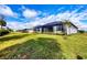A spacious backyard with lush green grass and manicured landscaping behind the house at 2088 Bonito Way, Port Charlotte, FL 33953
