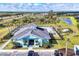 A clubhouse is surrounded by palm trees, green grass, and a large parking lot at 2088 Bonito Way, Port Charlotte, FL 33953