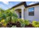 Inviting front entryway framed by an arched portico and lush landscaping featuring palm trees at 2088 Bonito Way, Port Charlotte, FL 33953