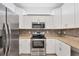 Modern kitchen with stainless steel appliances, granite countertops, and white cabinetry at 2088 Bonito Way, Port Charlotte, FL 33953