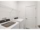 Functional laundry room area featuring a washer, dryer, shelving, and a door at 2088 Bonito Way, Port Charlotte, FL 33953