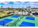 Bright green and blue pickleball courts sit next to a blue community clubhouse with green palms at 2088 Bonito Way, Port Charlotte, FL 33953