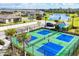An aerial view of a pickleball court shows green and blue playing surfaces with palms and homes beyond at 2088 Bonito Way, Port Charlotte, FL 33953