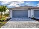 Two-car garage with paved driveway, well-maintained landscaping, and a modern exterior at 2088 Bonito Way, Port Charlotte, FL 33953