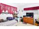 A comfy bedroom with a television, patterned bedding, and a red curtain at 22032 Felton Ave, Port Charlotte, FL 33952