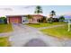 Inviting single-story home featuring a well-manicured lawn, mature landscaping, and a charming exterior at 22032 Felton Ave, Port Charlotte, FL 33952