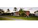 Lovely single-story home boasting mature palm trees, a green lawn, and a well-maintained exterior at 22032 Felton Ave, Port Charlotte, FL 33952